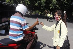 Foto: Salah seorang mahasiswa STPM sedang membagikan bunga anti korupsi kepada pengendara sepeda motor di Jalan Eltari Ende, Jumad (9/12) (Foto : Ian Bala)